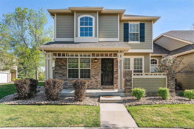 view of front facade featuring a front lawn, brick siding, and covered porch