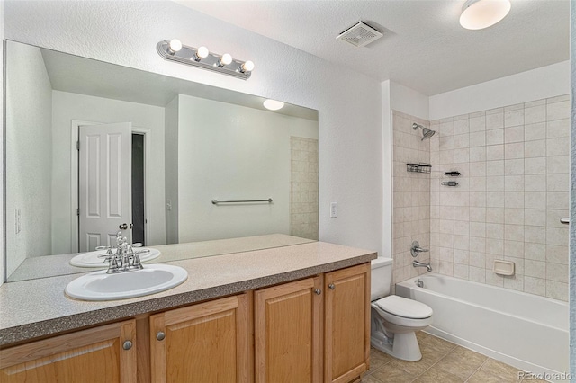 bathroom featuring toilet, tile patterned floors, vanity, and bathing tub / shower combination