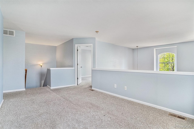 carpeted empty room featuring baseboards
