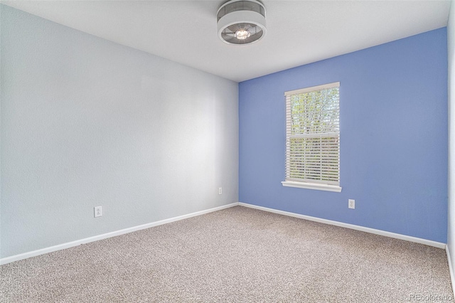 unfurnished room with carpet floors and baseboards