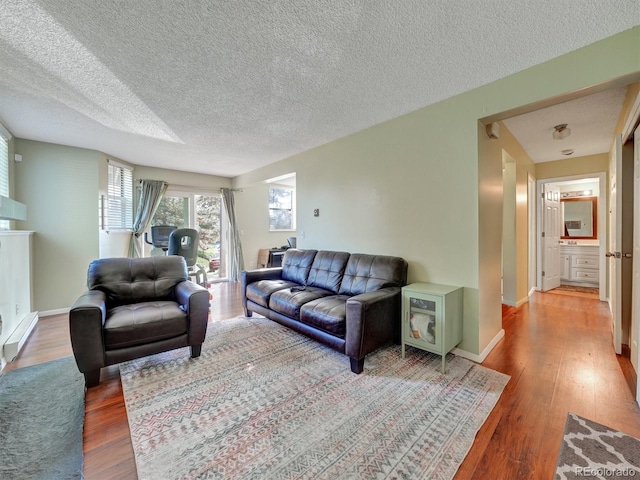 17505 E Mansfield Ave Unit 1411L, Aurora, CO 80013 - living area with a textured ceiling, wood finished floors, and baseboards