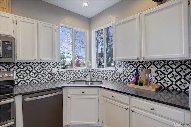 kitchen with white cabinetry, tasteful backsplash, appliances with stainless steel finishes, and a sink