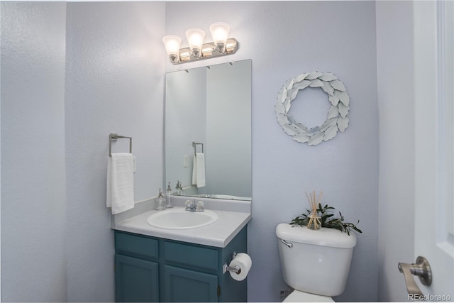 half bathroom with toilet and vanity