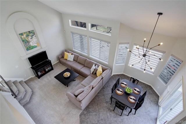 living room with baseboards, plenty of natural light, an inviting chandelier, and carpet flooring