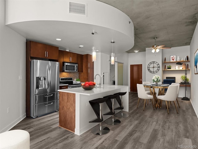 kitchen featuring visible vents, baseboards, light countertops, dark wood finished floors, and stainless steel appliances