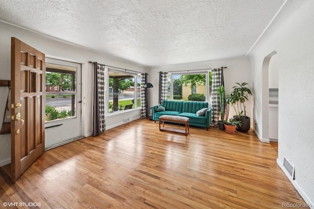 113 S 4th Ave, Brighton, CO 80601 - sitting room featuring a textured ceiling, wood finished floors, arched walkways, and baseboards
