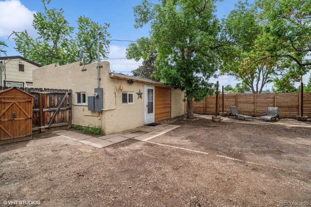 113 S 4th Ave, Brighton, CO 80601 - rear view of property with a fenced backyard, a gate, a patio, and stucco siding
