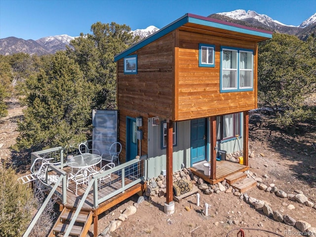 view of side of property with outdoor dining space and a mountain view