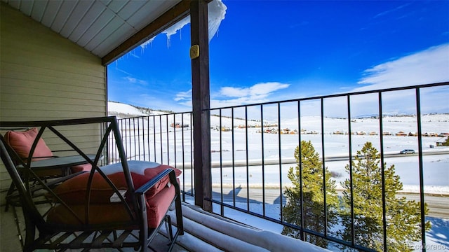 view of snow covered back of property