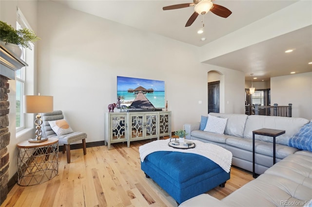living area with recessed lighting, arched walkways, ceiling fan, and wood finished floors
