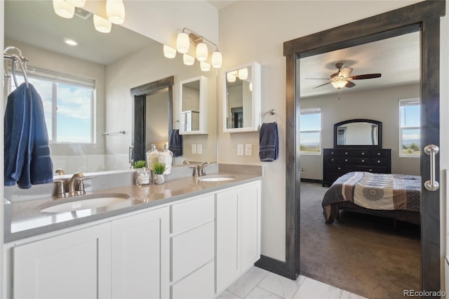 bathroom with double vanity, ceiling fan, a sink, and ensuite bathroom