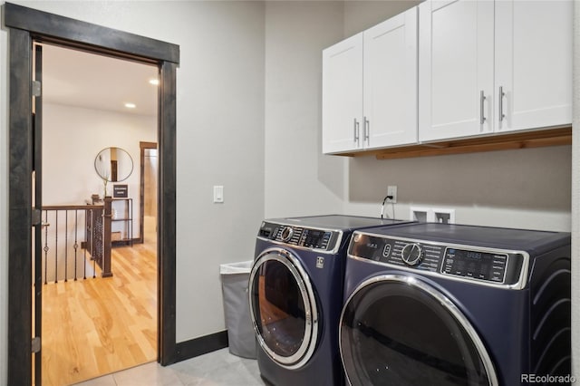 laundry area featuring cabinet space, separate washer and dryer, and baseboards