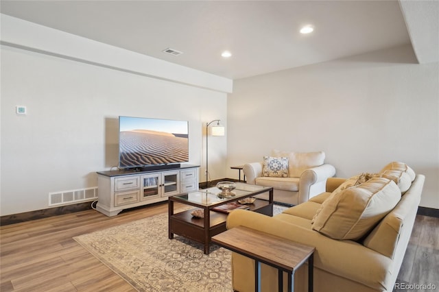 living room with visible vents, baseboards, and light wood finished floors