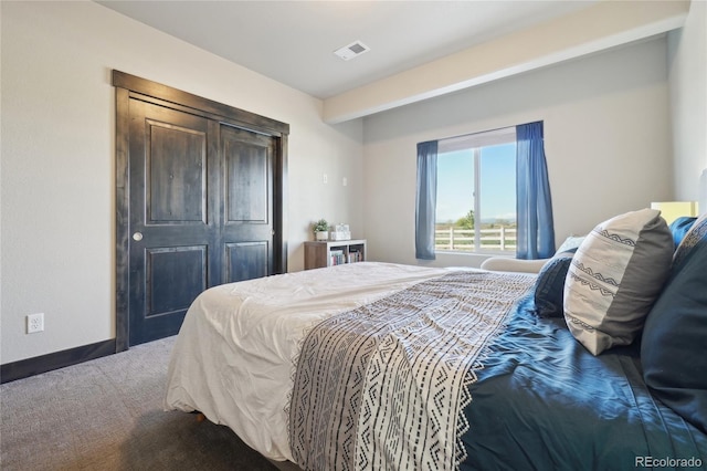 carpeted bedroom with visible vents and a closet