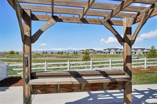 view of patio / terrace with a pergola and a rural view