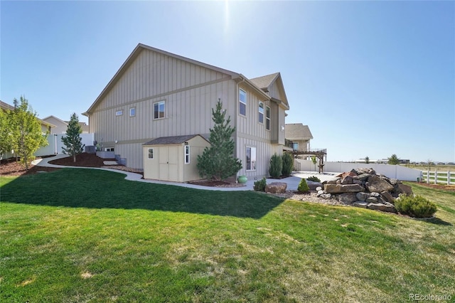 back of property with a yard, a pergola, board and batten siding, and a fenced backyard