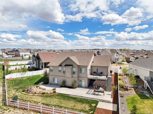 rear view of house featuring a residential view, a fenced backyard, and roof with shingles