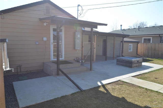 rear view of house featuring a patio, french doors, fence, and a fire pit