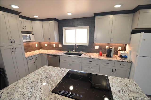kitchen featuring decorative backsplash, a sink, white appliances, and light stone countertops