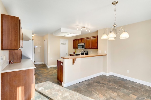 kitchen featuring a breakfast bar, decorative light fixtures, kitchen peninsula, stainless steel appliances, and a chandelier