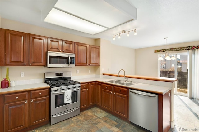 kitchen featuring pendant lighting, sink, appliances with stainless steel finishes, a notable chandelier, and kitchen peninsula