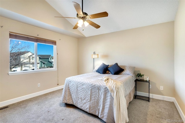 bedroom featuring light colored carpet, vaulted ceiling, and ceiling fan