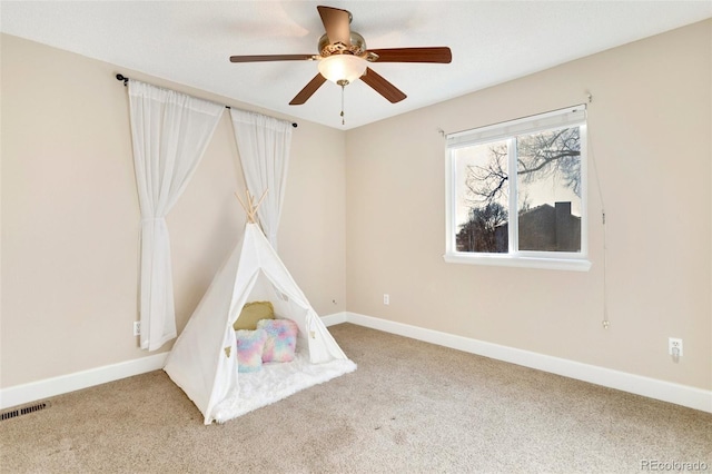 recreation room with light carpet and ceiling fan