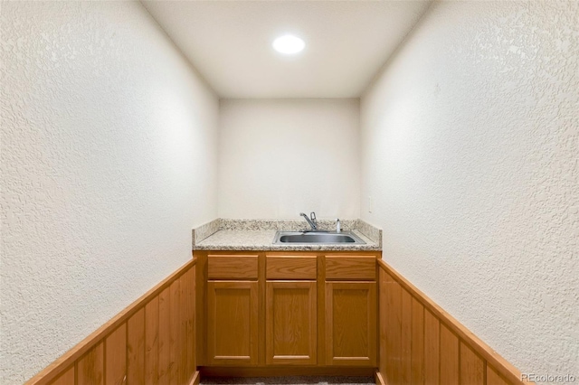 bar featuring wood walls and sink