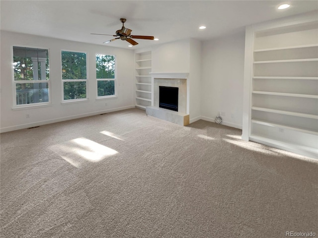 24955 E Roxbury Pl, Aurora, CO 80016 - unfurnished living room featuring built in features, a ceiling fan, carpet flooring, a tile fireplace, and recessed lighting