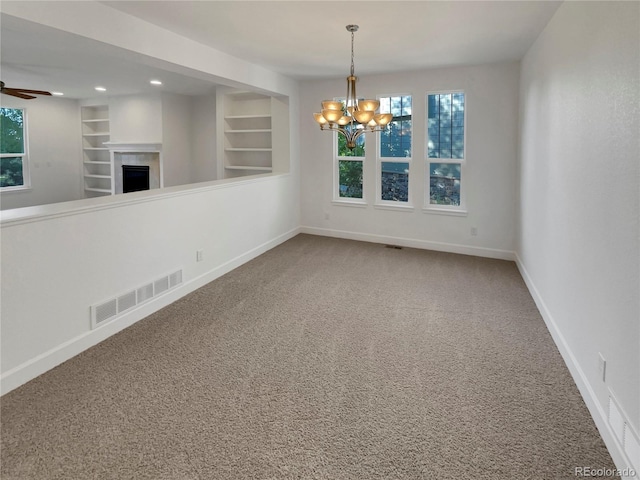 24955 E Roxbury Pl, Aurora, CO 80016 - unfurnished room featuring carpet floors, a chandelier, a fireplace, a ceiling fan, and built in shelves