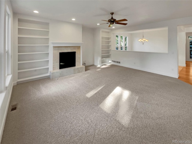 24955 E Roxbury Pl, Aurora, CO 80016 - unfurnished living room featuring ceiling fan, built in features, recessed lighting, a tile fireplace, and carpet flooring