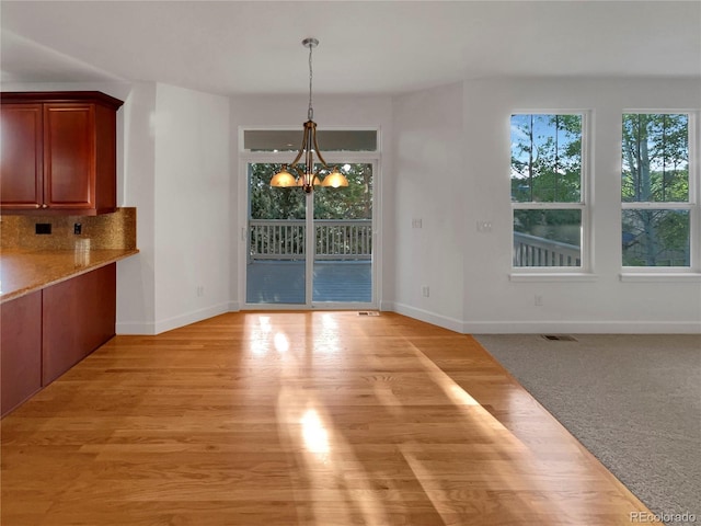 24955 E Roxbury Pl, Aurora, CO 80016 - unfurnished dining area with a chandelier and light wood-style flooring