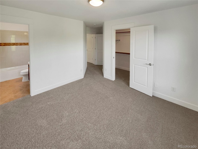 24955 E Roxbury Pl, Aurora, CO 80016 - unfurnished bedroom featuring carpet, a closet, a spacious closet, and ensuite bath