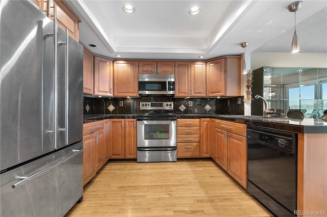 7160 W Stetson Pl Unit 27, Littleton, CO 80123 - kitchen featuring appliances with stainless steel finishes, a sink, tile countertops, a raised ceiling, and light wood-style flooring