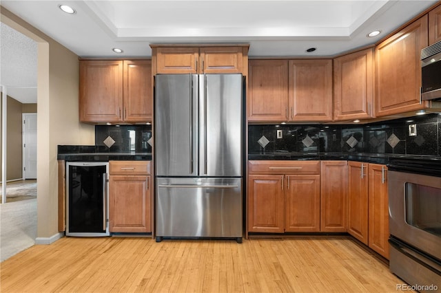 7160 W Stetson Pl Unit 27, Littleton, CO 80123 - kitchen featuring stainless steel appliances, beverage cooler, a tray ceiling, recessed lighting, and brown cabinets