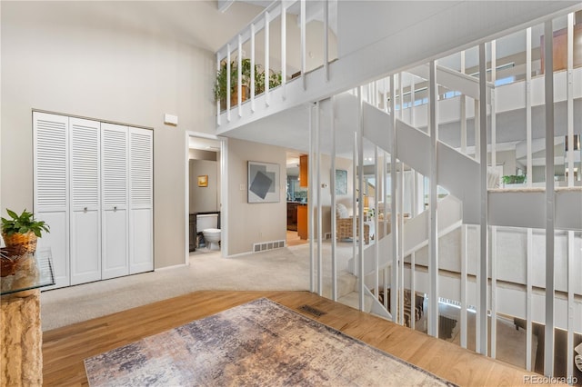 7160 W Stetson Pl Unit 27, Littleton, CO 80123 - stairway with a high ceiling, baseboards, wood finished floors, and carpet flooring