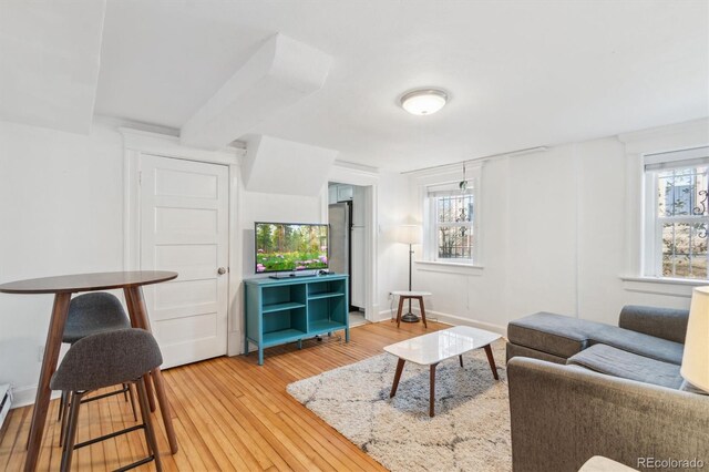living room with light wood finished floors, baseboards, and a baseboard radiator