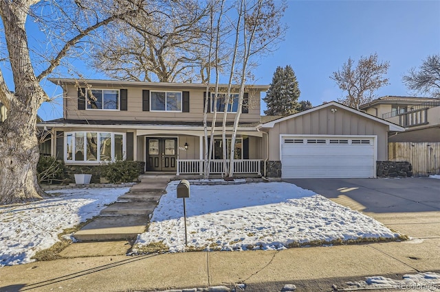 view of front property featuring french doors, covered porch, and a garage