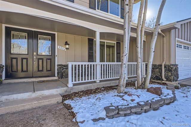 snow covered property entrance featuring a porch