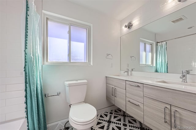 bathroom with toilet, tile patterned floors, and vanity