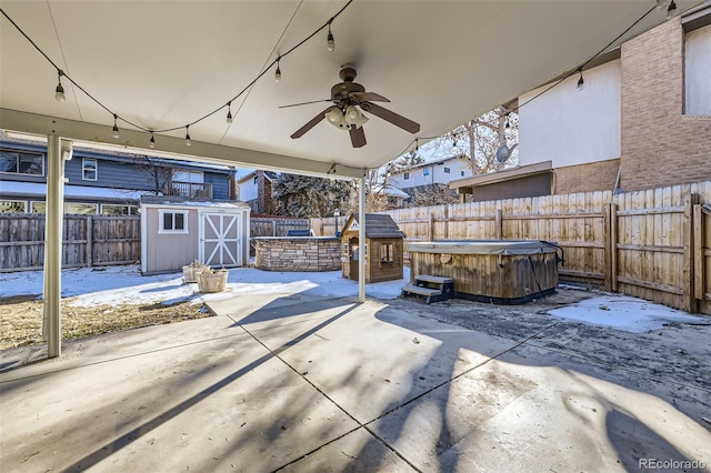 view of patio with ceiling fan, a shed, and a hot tub