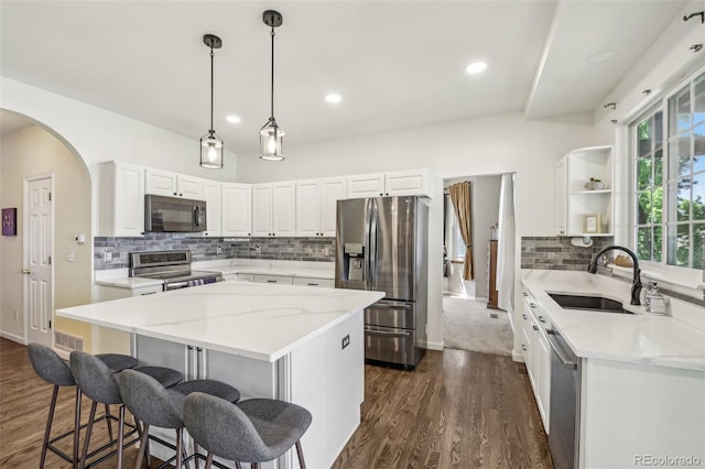 7513 Simms Ct, Arvada, CO 80005 - kitchen featuring stainless steel appliances, a sink, open shelves, light stone counters, and recessed lighting