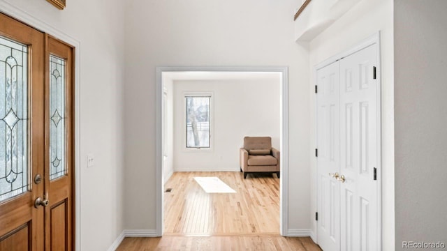 foyer entrance featuring baseboards and light wood finished floors