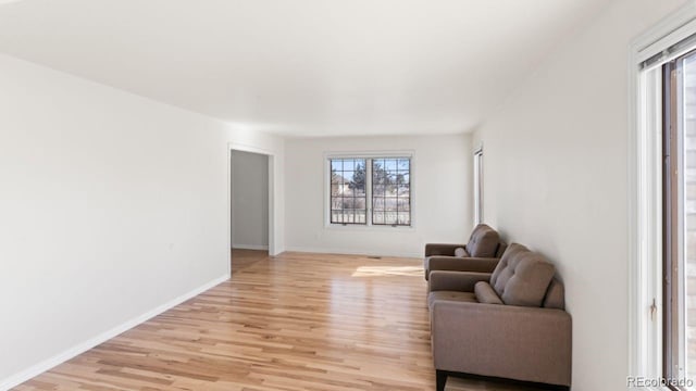 living area with light wood finished floors and baseboards