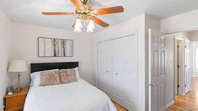 bedroom with light wood finished floors, a ceiling fan, and a closet