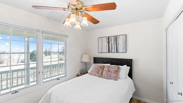 bedroom with a closet, ceiling fan, and baseboards