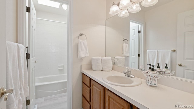 full bathroom featuring shower / bathing tub combination, a skylight, and vanity