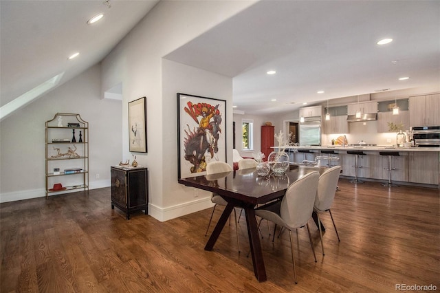 dining room with dark hardwood / wood-style flooring and lofted ceiling