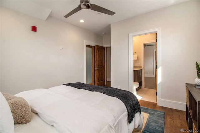 bedroom with connected bathroom, ceiling fan, and hardwood / wood-style flooring