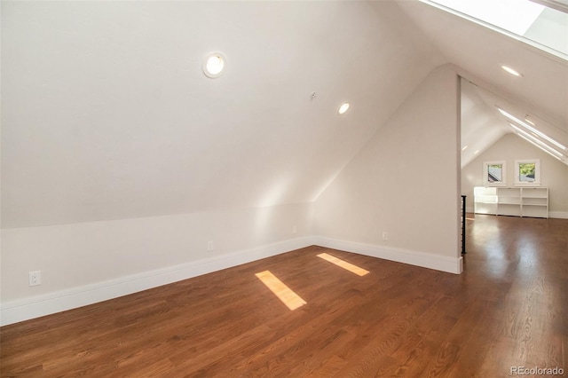 additional living space with dark hardwood / wood-style floors and lofted ceiling with skylight